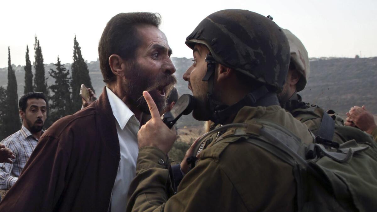 A Palestinian man argues with an Israeli soldier in the town of as-Sawiyah, south of Nablus last month in the occupied West Bank. This week Israeli Prime Minister Benjamin Netanyahu disputed the idea that the West Bank, administered by the Israeli army, is occupied territory.