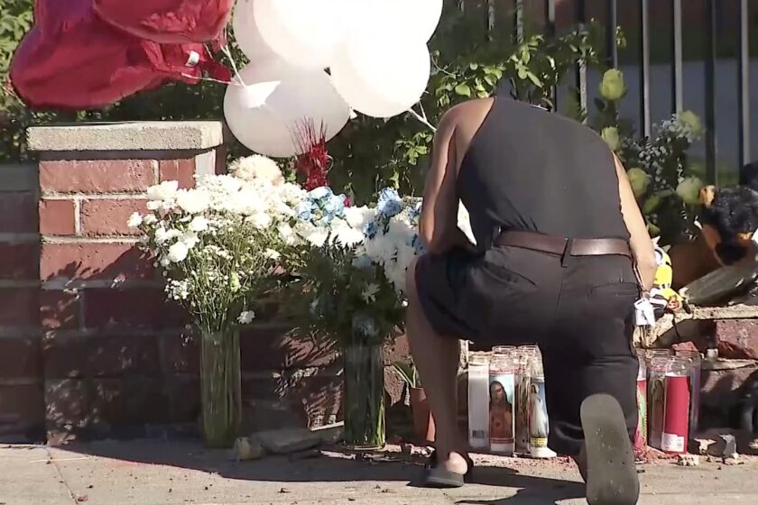 A man kneels in front of a memorial for an 18-month-old boy that was killed after a hit-and-run crash 
