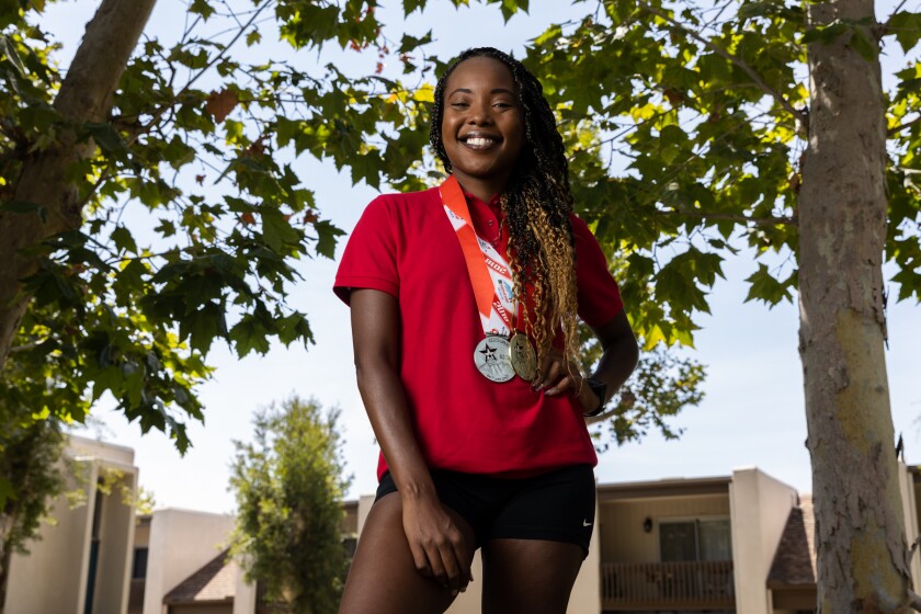 Kidney donor Eryn Roberts poses with medals she won in previous Transplant Games events 