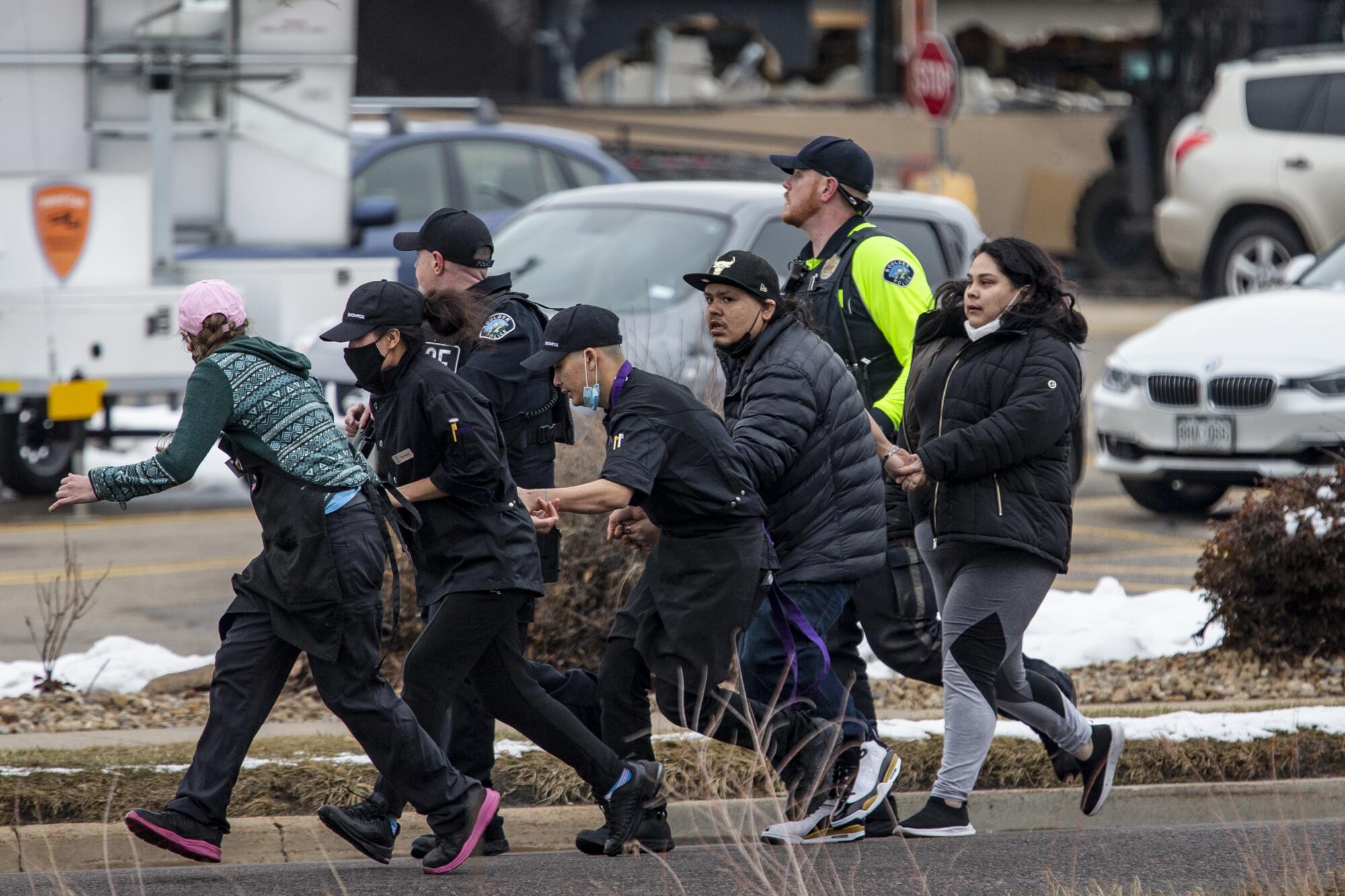Shoppers are evacuated from a King Soopers grocery store after a gunman opened fire Monday in Boulder, Colo.