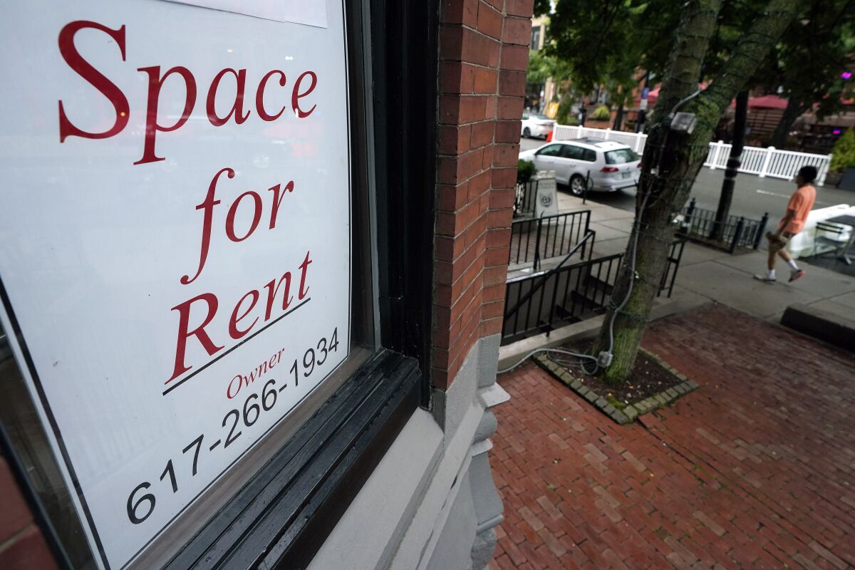 FILE - In this Sept. 2, 2020 file photo, a passer-by walks past a business storefront with a space for rent sign in a window in Boston. Business applications were the highest on record in 2020, up 24% from the previous year. You may be considering joining that trend if you don’t want to return to an office or were laid off during the pandemic. (AP Photo/Steven Senne, File)