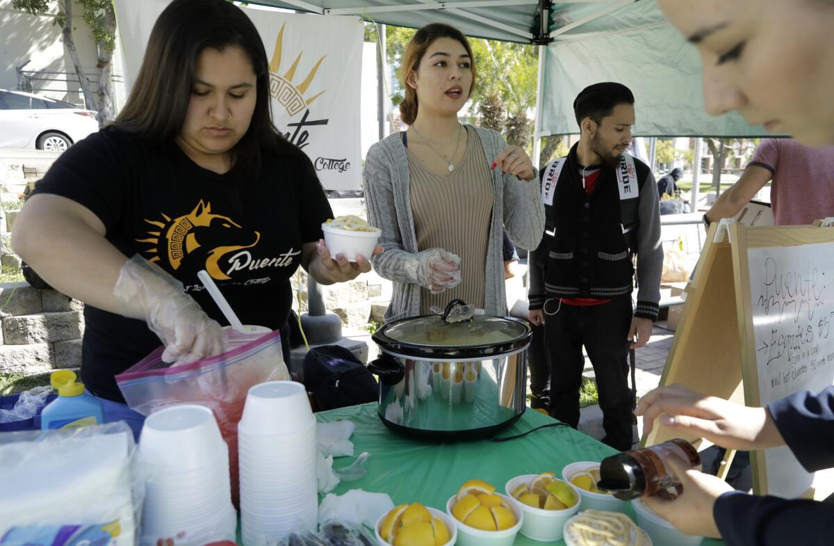 Vanessa Miranda, left, and Destiny Ramirez sell corn at East Los Angeles College to raise money for their college transfer club Puente. The students hope to get accepted to schools like UCLA and UC Davis.