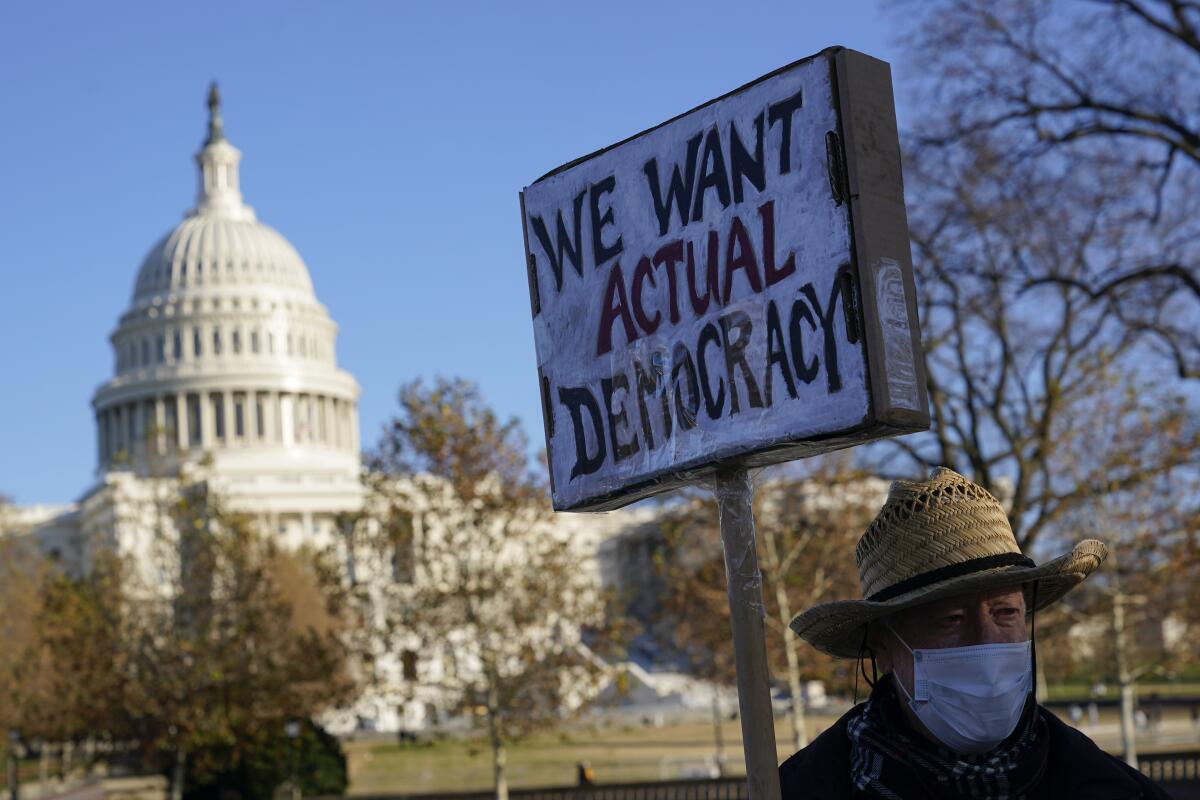 Protester David Barrows carries a sign to press Congress to pass voting rights protections and the "Build Back Better Act" 