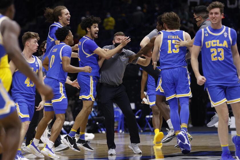 INDIANAPOLIS, INDIANA - MARCH 30: The UCLA Bruins celebrate defeating the Michigan Wolverines 51-49 in the Elite Eight round game of the 2021 NCAA Men's Basketball Tournament at Lucas Oil Stadium on March 30, 2021 in Indianapolis, Indiana. (Photo by Jamie Squire/Getty Images)