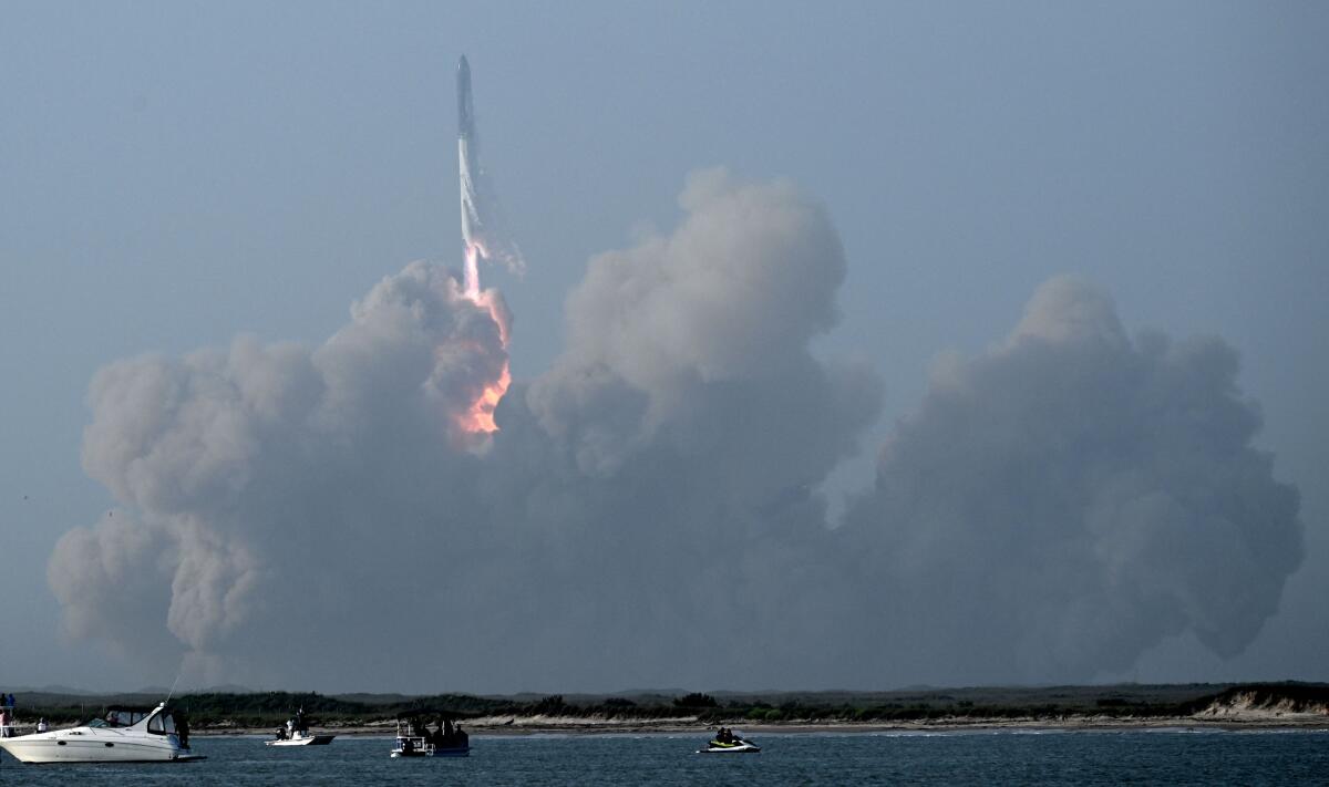 A rocket lifts off amid a cloud of smoke.