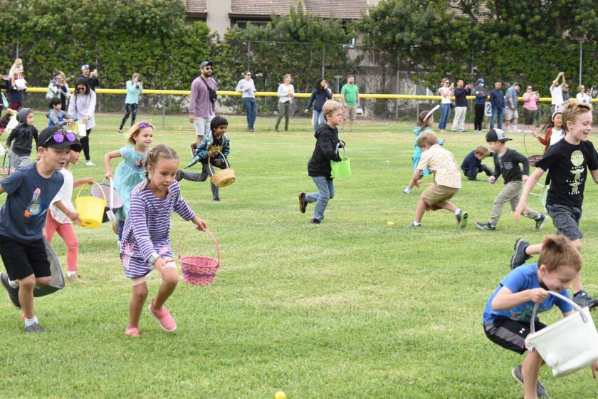 Children run to find eggs in the Westwood Club’s Easter egg hunt on Saturday morning.