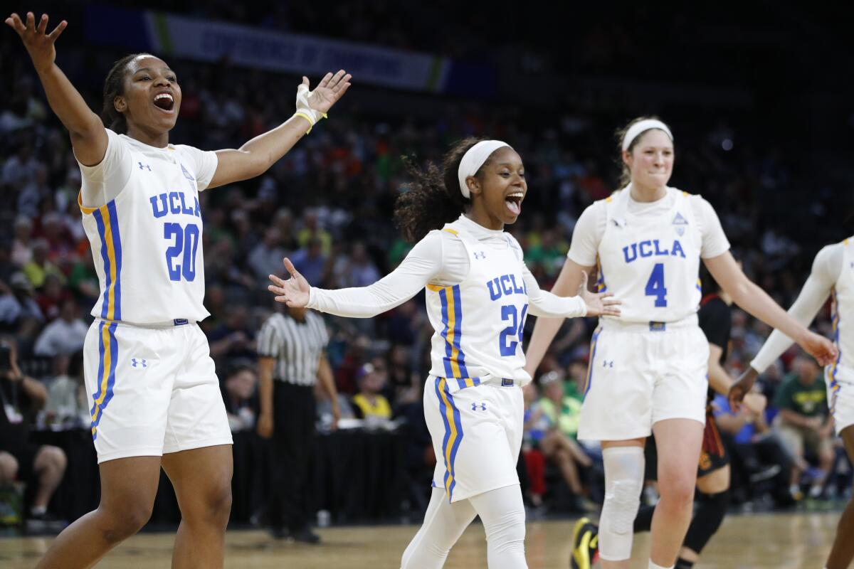 UCLA's Charisma Osborne, left, Japreece Dean, center, and Lindsey Corsaro celebrate after a play against USC during the second half in the quarterfinal round of the Pac-12 women's tournament on March 6 in Las Vegas.