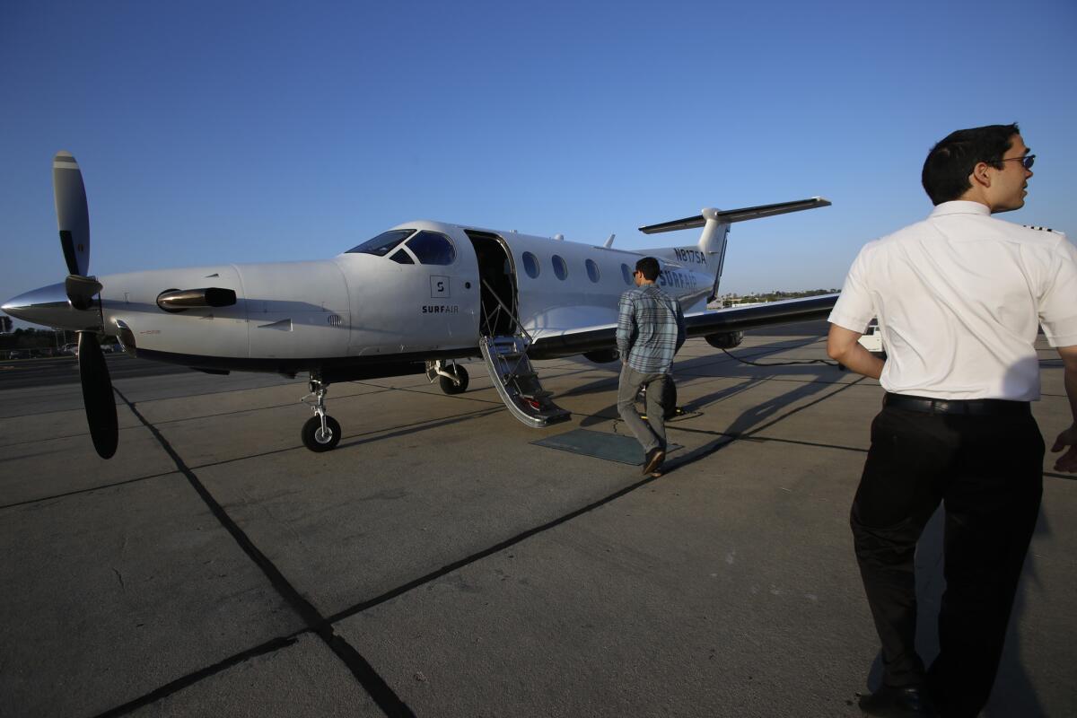 Captain Chris Pimentel, right, waits for passengers to board the SurfAir airplane at the Hawthorne Municipal Airport in Hawthorne last year. SurfAir is an all-you-can-fly membership airline.