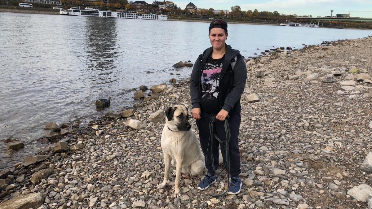 Cynthia Medzech with her dog Berfin along the gravel banks in Cologne where the Rhine river usually flows. The spot she is standing at is normally 10 feet below water and about 200 feet from the usual shoreline.