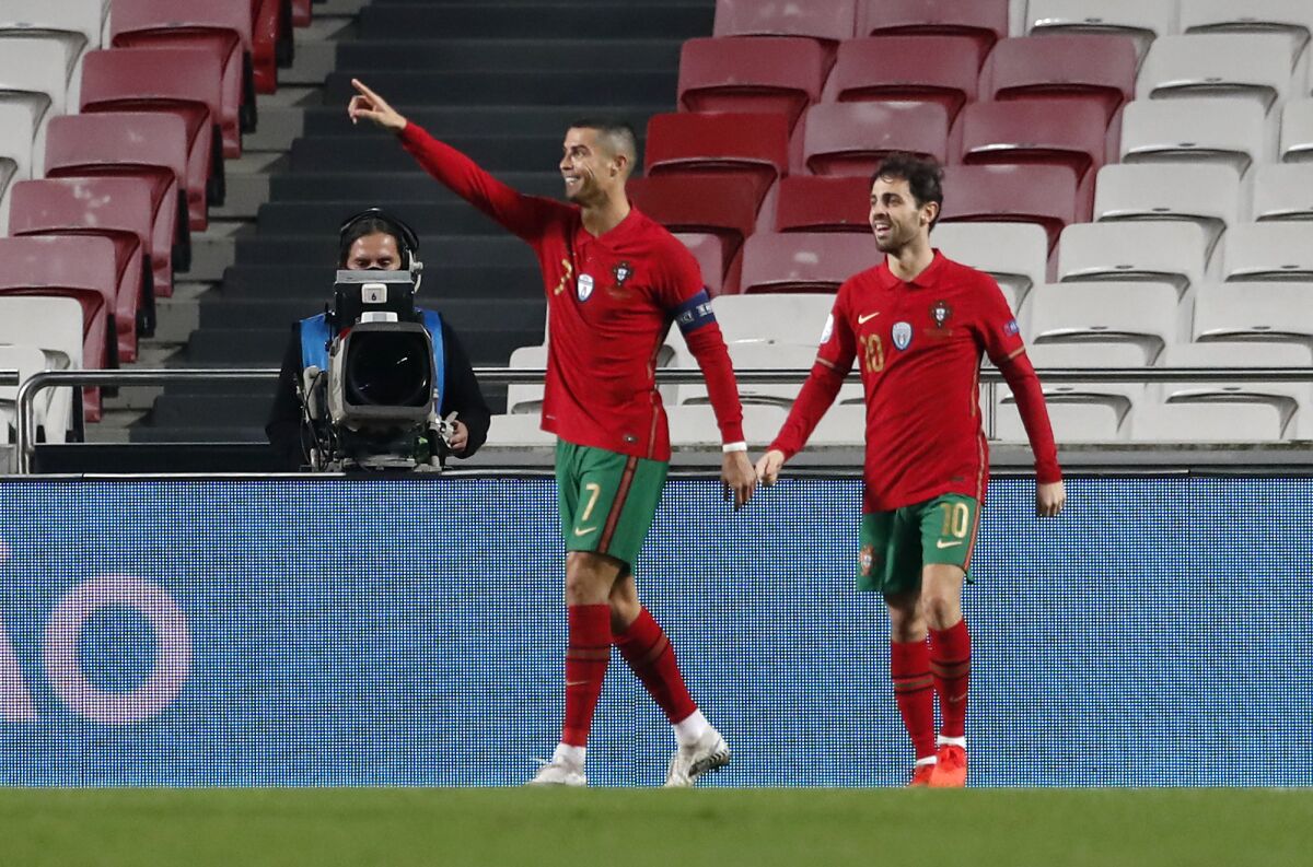 Cristiano Ronaldo (izquierda), de la selección de Portugal, es felicitado por su compañero Bernardo Silva tras anotar ante Andorra, el miércoles 11 de noviembre de 2020 (AP Foto/Armando Franca)
