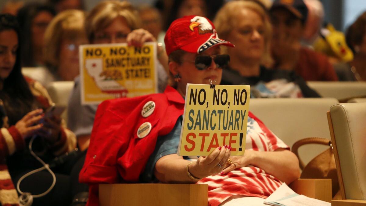 Opponents of California's Senate Bill 54, a key "sanctuary state" law, display signs during a Newport Beach City Council meeting Tuesday night.