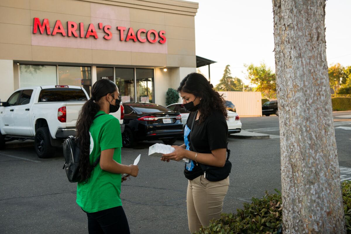 Melissa Lopez (left) and Alma Gallegos get ready to distribute c