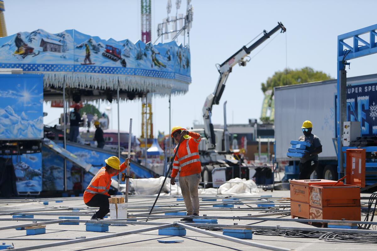 A crew sets up a ride Friday at the Orange County fairgrounds in Costa Mesa.