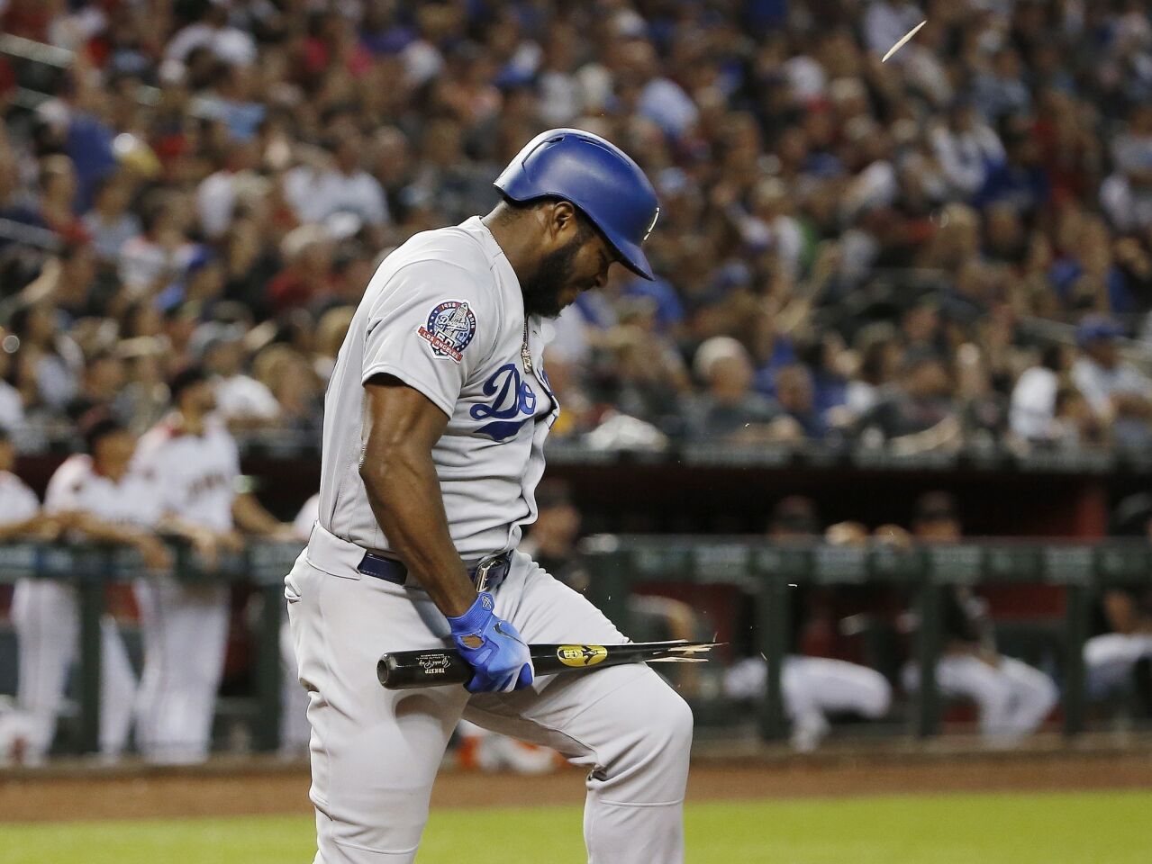 Los Angeles Dodgers' Yasiel Puig breaks his bat over his leg after flyiing out against the Arizona Diamondbacks during the fifth inning of a baseball game Wednesday, Sept. 26, 2018, in Phoenix. (AP Photo/Ross D. Franklin)