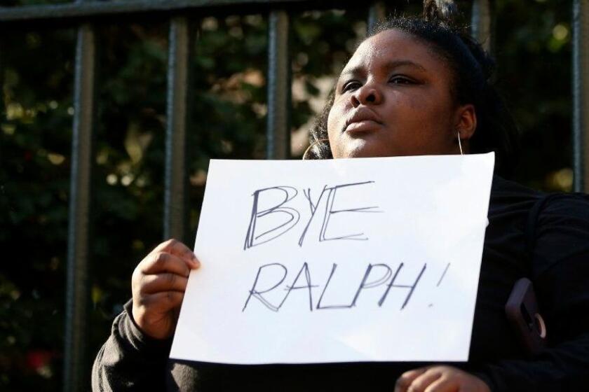 Zyahna Bryant of Charlottesville holds a sign at a protest calling for Governor Ralph Northam to resign on Monday Feb. 4, 2019 after photos surfaced from Northam's 1984 Eastern Virginia Medical School yearbook depicting one person in blackface and another in a Ku Klux Klan outfit. (Shelby Lum/Richmond Times-Dispatch via AP)