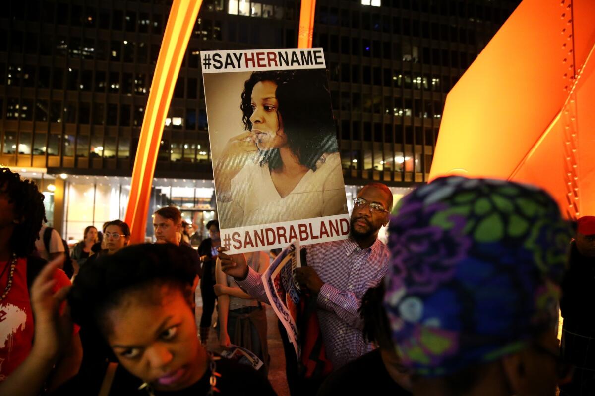 Tokunbo Adenekan of Baltimore holds a sign during a candlelight vigil in Chicago in July to mark the one-year anniversary of Sandra Bland's death. (Chris Sweda / Associated Press)