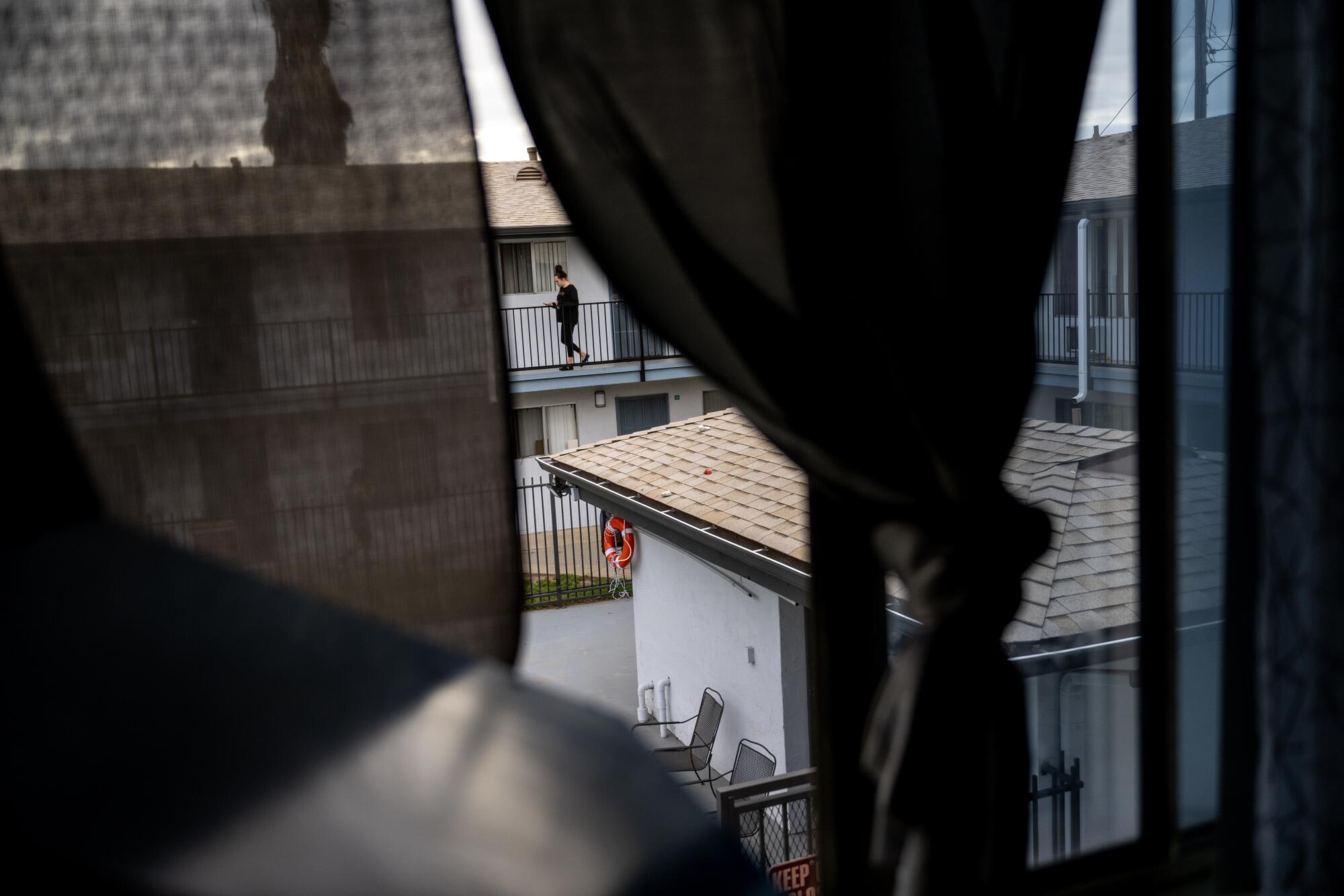 A person walks along a second floor balcony.