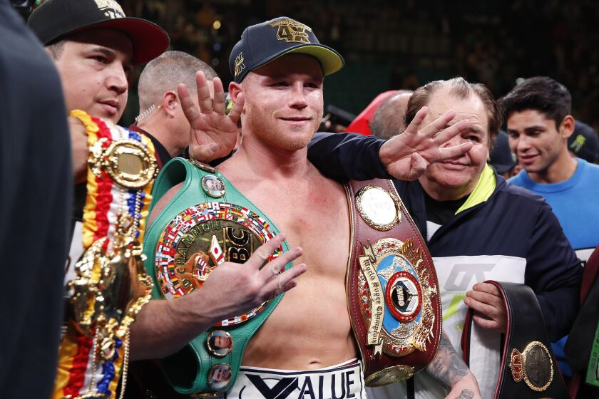 Canelo Alvarez poses for photos after defeating Sergey Kovalev by knockout in a light heavyweight WBO title.