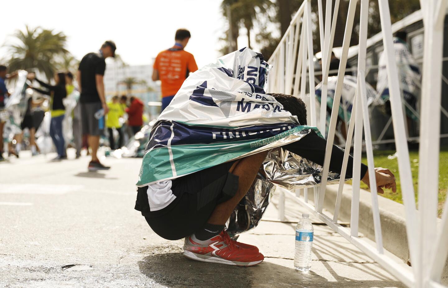 Race participant Horacio Gonzalez, 42, of Los Angeles, stretches after finishing the L.A. Marathon on Sunday.
