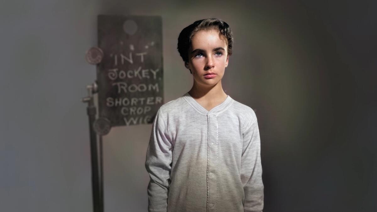 Elizabeth Taylor as a child in a white, long-sleeve top.