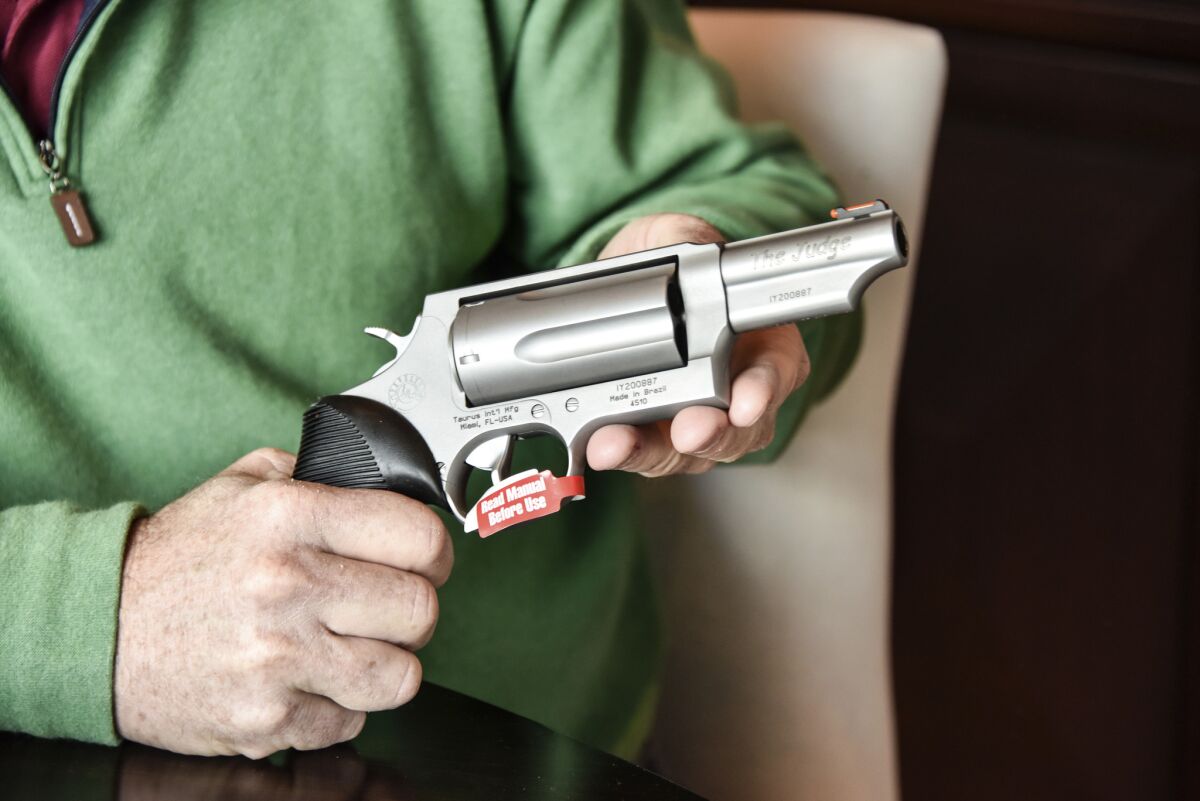 Lance Toland, the owner of Lance Toland Associates, an aviation insurance company with three offices in Georgia, holds a Taurus revolver, in Atlanta on Feb. 26, 2016.