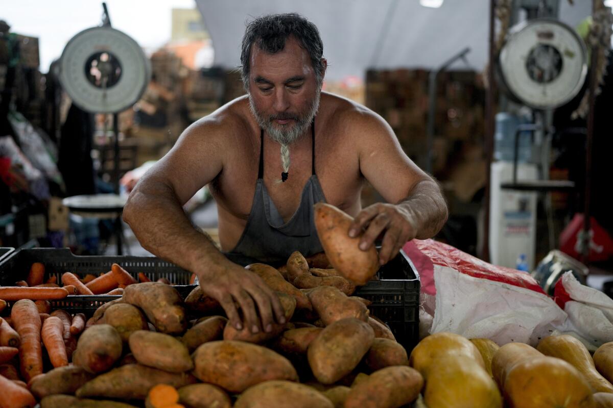 El vendedor Rubén Bolush coloca patatas a la venta en el mercado central de Buenos Aires, Argentina, 