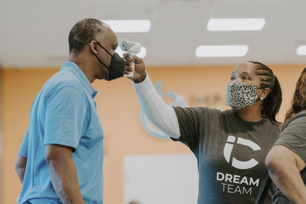 Man getting his temperature taken at a vaccination event