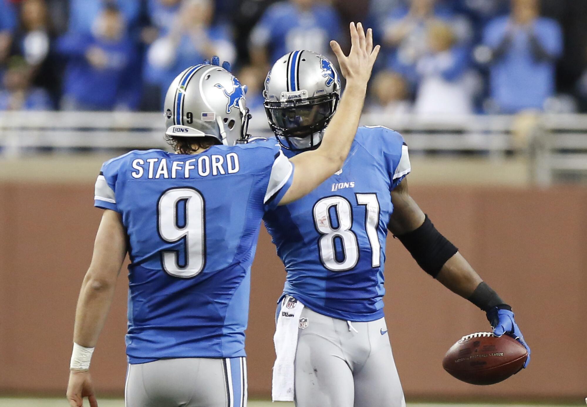 The Lions' Calvin Johnson (81) is congratulated by Matthew Stafford.