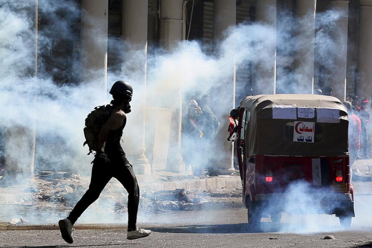 Iraqi riot police fire tear gas to disperse anti-government protesters in Baghdad on Friday.