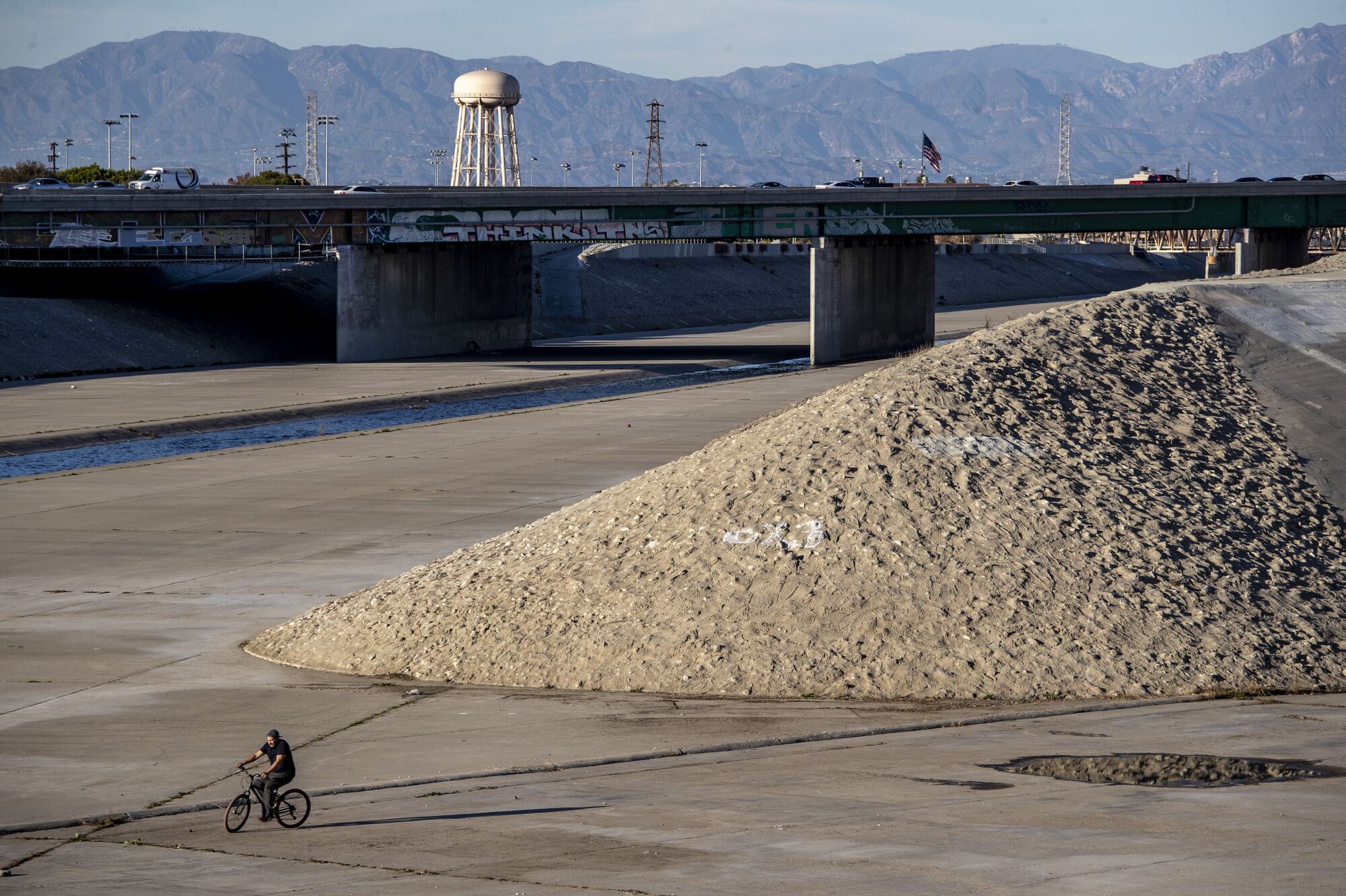 A cyclist rides in the Los Angeles River near what might be Confluence Point Park Sunday, Jan. 10, 2021 in South Gate.
