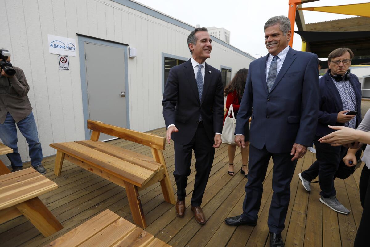 Mayor Eric Garcetti, left, and shelter operator John Maceri in the courtyard of the new shelter. "This is not just about the 45 individuals, it's about the next 45 individuals and the next after that," Maceri said.