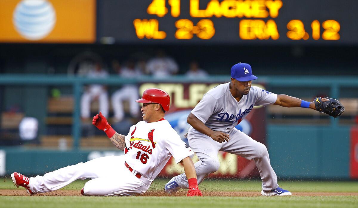 St. Louis Cardinals' Kolten Wong slides into second base safely ahead of the tag by Dodgers shortstop Jimmy Rollins during the first inning Friday.