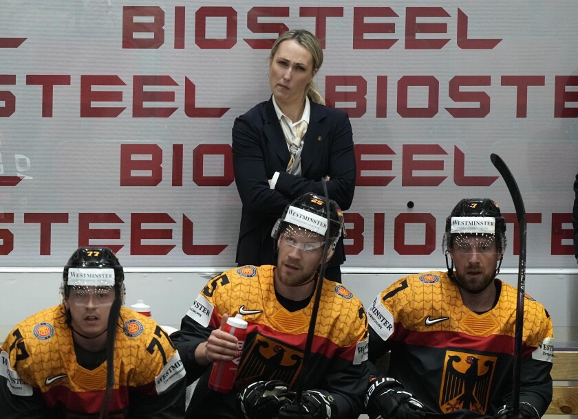 FILE - Germany's assistant coach Jessica Campbell stands behind players on the German bench during the group A Hockey World Championship match between France and Germany in Helsinki, Finland, Monday May 16, 2022. The Coachella Valley Firebirds have hired Jessica Campbell as the American Hockey League’s first female assistant coach. (AP Photo/Martin Meissner, File)
