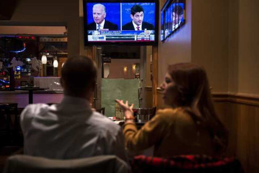 A couple is seen watching the Vice Presidential debate at a Washington D.C. restaurant.