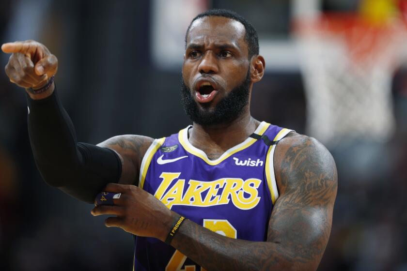Los Angeles Lakers forward LeBron James directs teammates during the first half of the team's NBA basketball game against the Denver Nuggets on Wednesday, Feb. 12, 2020, in Denver. (AP Photo/David Zalubowski)