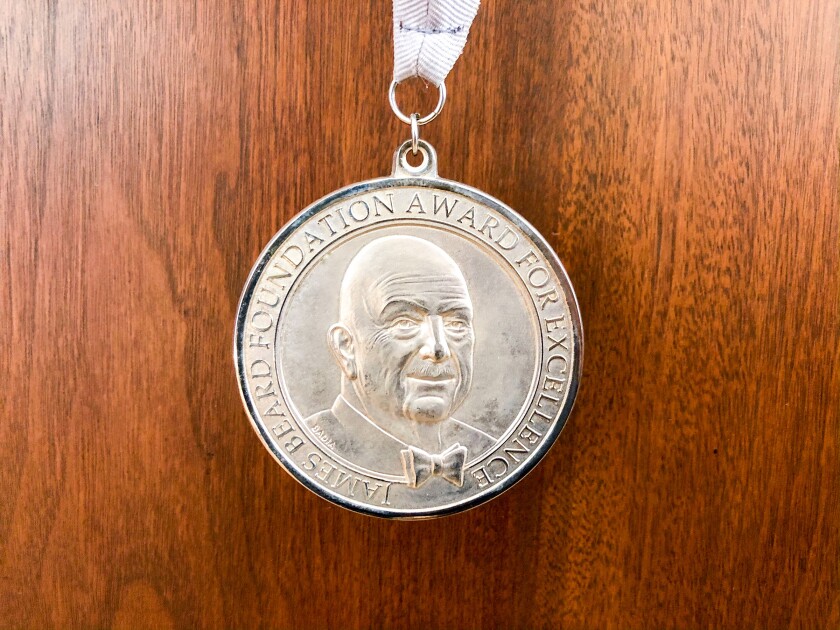 A photo of the silver James Beard medal presented to Bill Addison in 2020.