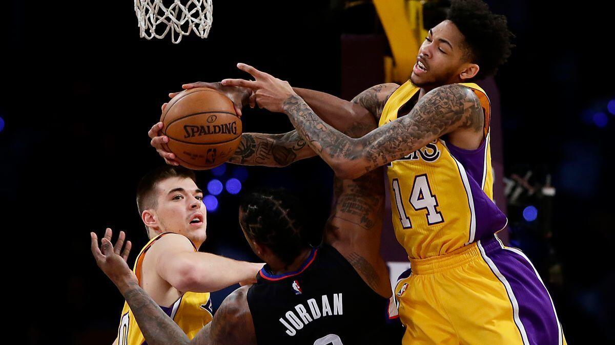 Clippers center DeAndre Jordan wrestles a rebound from Lakers forward Brandon Ingram as center Ivica Zubac looks on during first-half action at Staples Center.