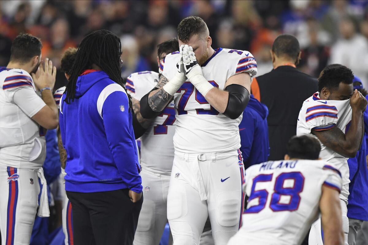Buffalo Bills offensive tackle covers his face pauses as Damar Hamlin is examined by medical staff 