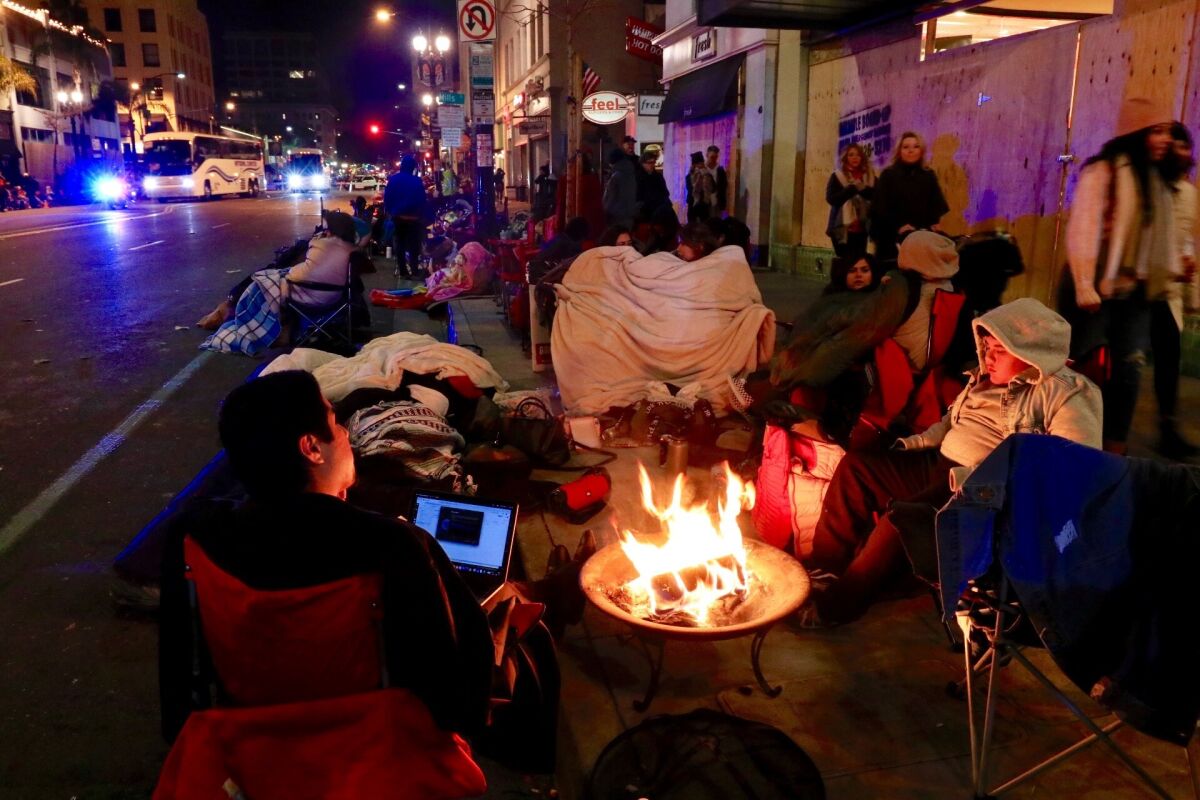 Campers stay warm in the hours before the start of the 2019 Rose Parade along Colorado Boulevard in Pasadena.