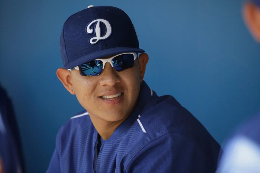 Pitcher Julio Urias talks to teammates in the Dodgers dugout during spring training.