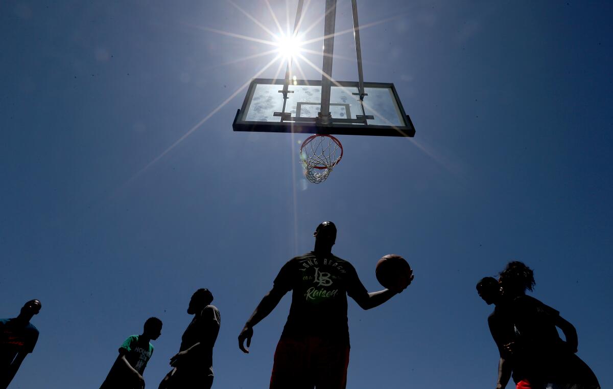 Players gather for pickup basketball on a court at  Junipero Beach in Long Beach.
