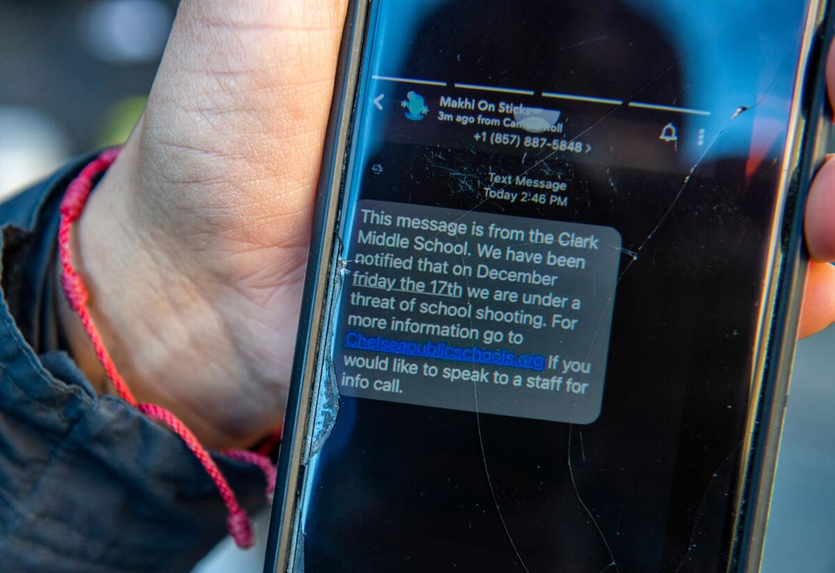 A mother in Chelsea, Mass., shows a text she received from her child's school regarding a threat of a school shooting Friday.