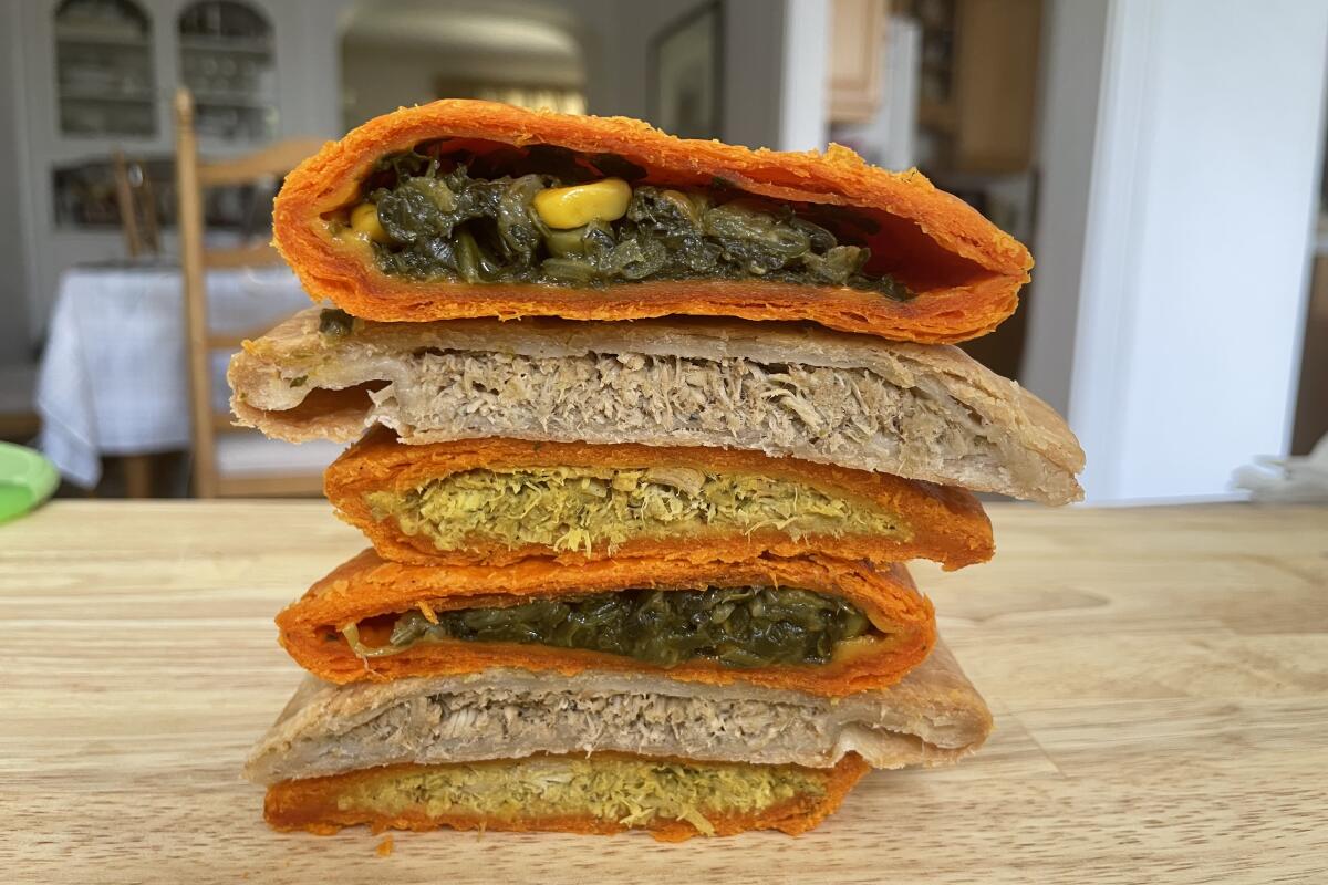 A stack of sliced-open Jamaican patties on a countertop