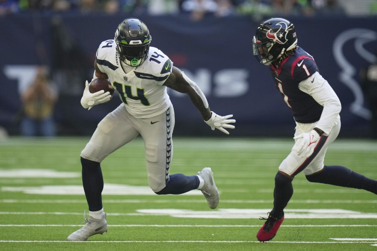 Seattle Seahawks wide receiver DK Metcalf, left, runs past Houston Texans free safety Lonnie Johnson.