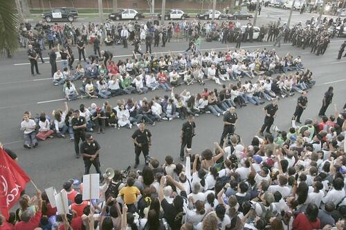 LAPD officers arrest protesters sitting in front of the Hilton Hotel on Century Boulevard.