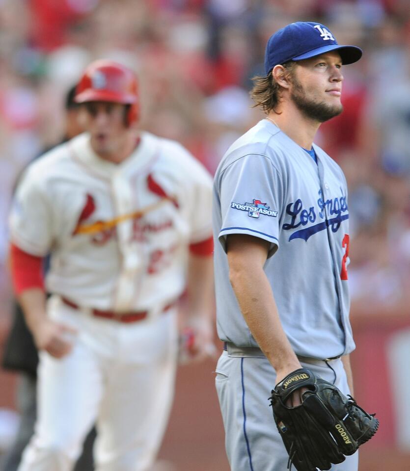 Dodgers pitcher Clayton Kershaw looks on as St. Louis third baseman David Freese, left, scores on a sacrifice fly in the fifth inning of Game 2 of the National League Championship Series.