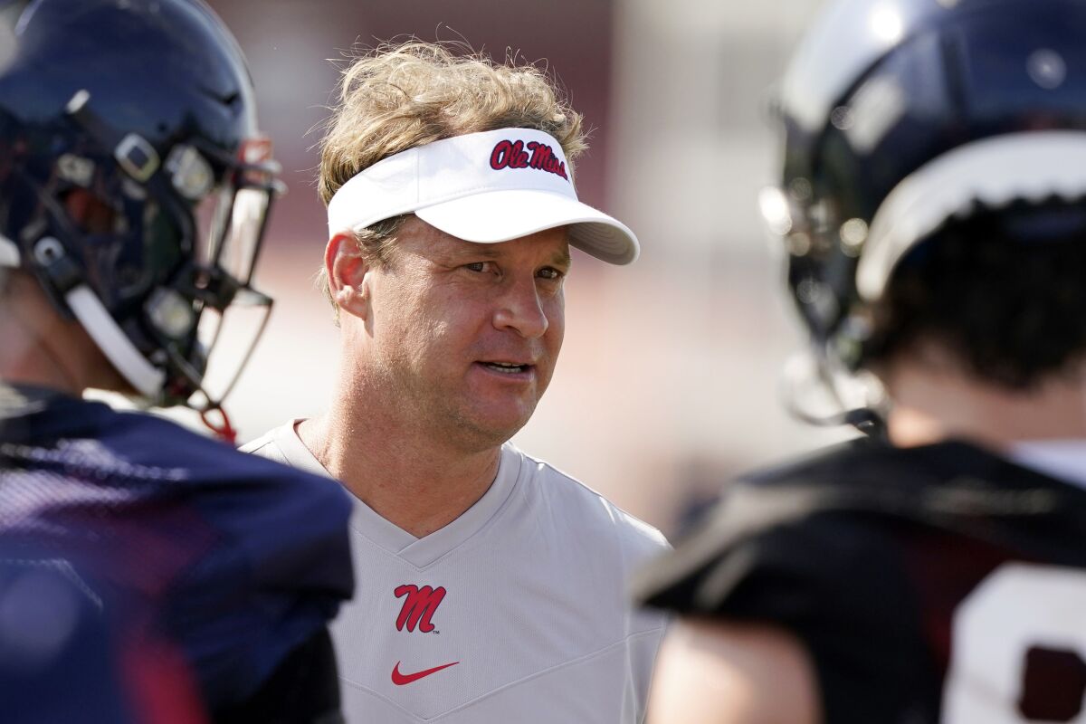 FILE - In this Aug. 9, 2021, file photo, Mississippi coach Lane Kiffin speaks with his players during NCAA college football practice in Oxford, Miss., Monday,. Mississippi takes on Louisville in Monday night’s Chick-Fil-A Kickoff game that wraps up college football’s first full weekend. (AP Photo/Rogelio V. Solis, File)