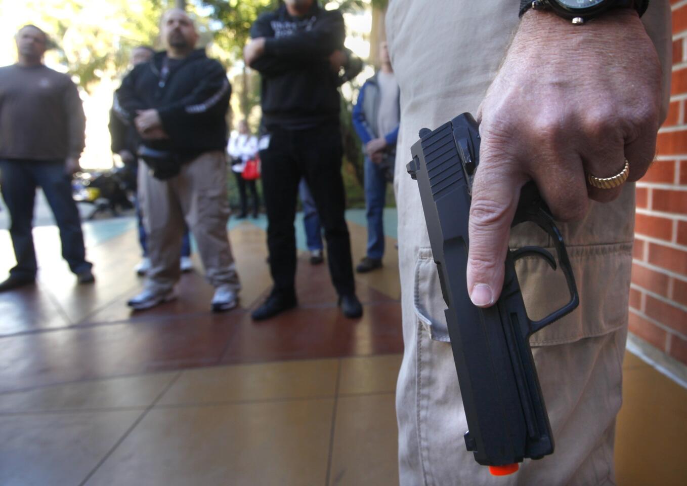 Instructor Bret Bandick holds an airsoft gun as he acts as a shooter at the Olmeca Residence Hall at San Diego State while police officers and school officials participate in the training exercise. The two-day Active Shooter Response Training aims to teach college and school officials and others what to do in the event of a mass shooting.