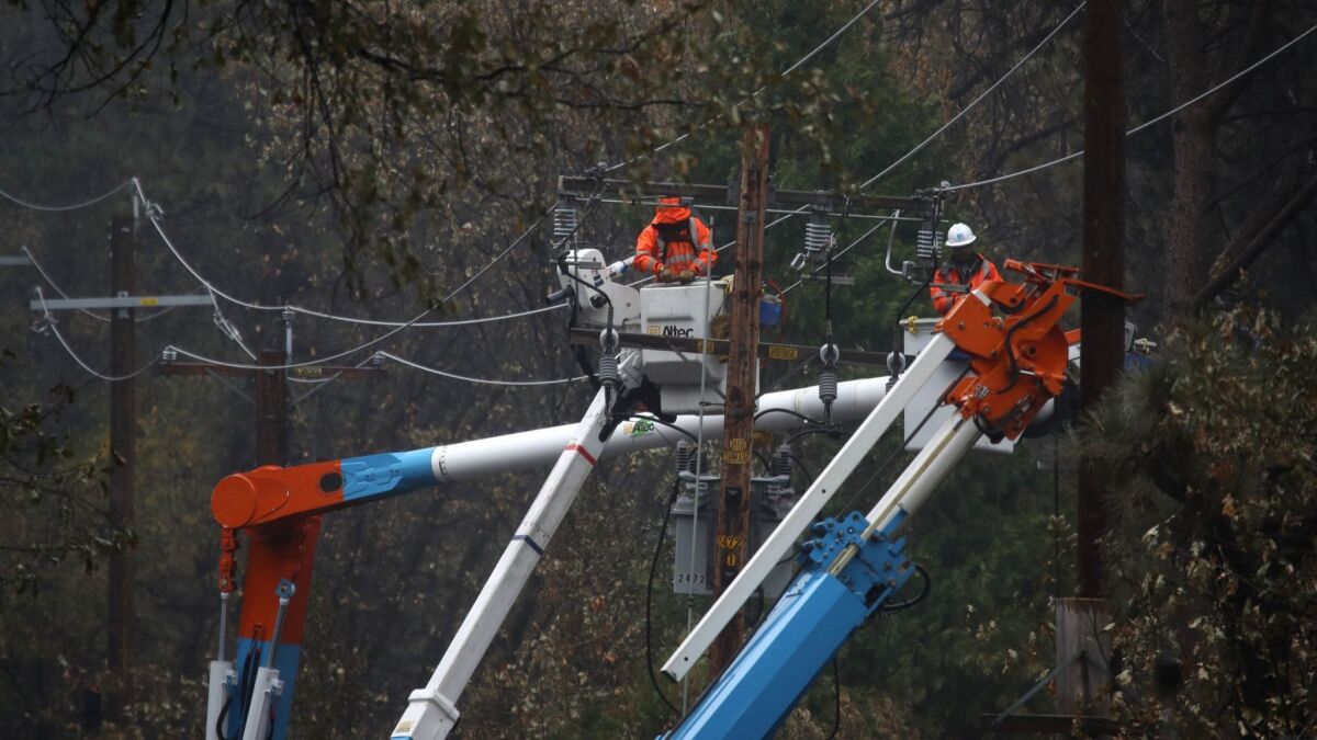 Pacific Gas & Electric crews repair power lines that were destroyed by the Camp fire near Paradise, Calif.