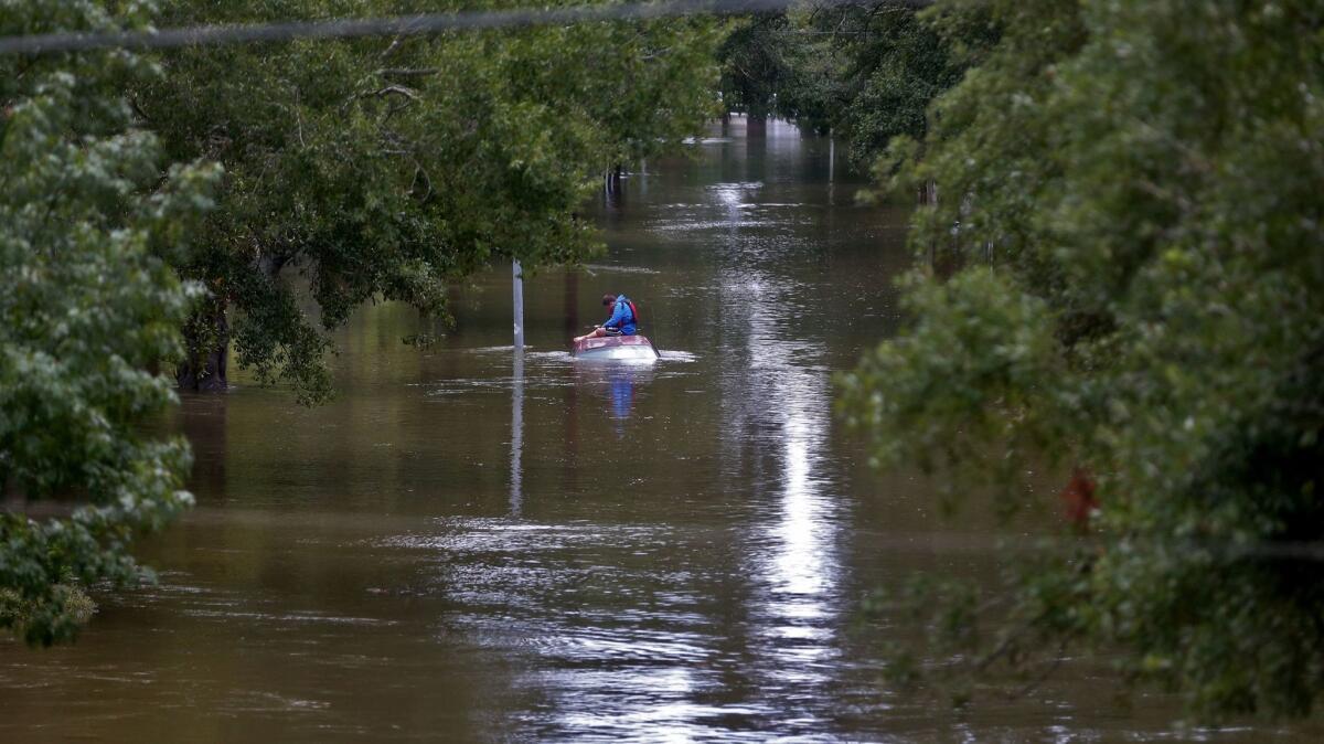 Daniel Gross, 15, sits on a car in southwest Houston, waiting for a rescue crew.